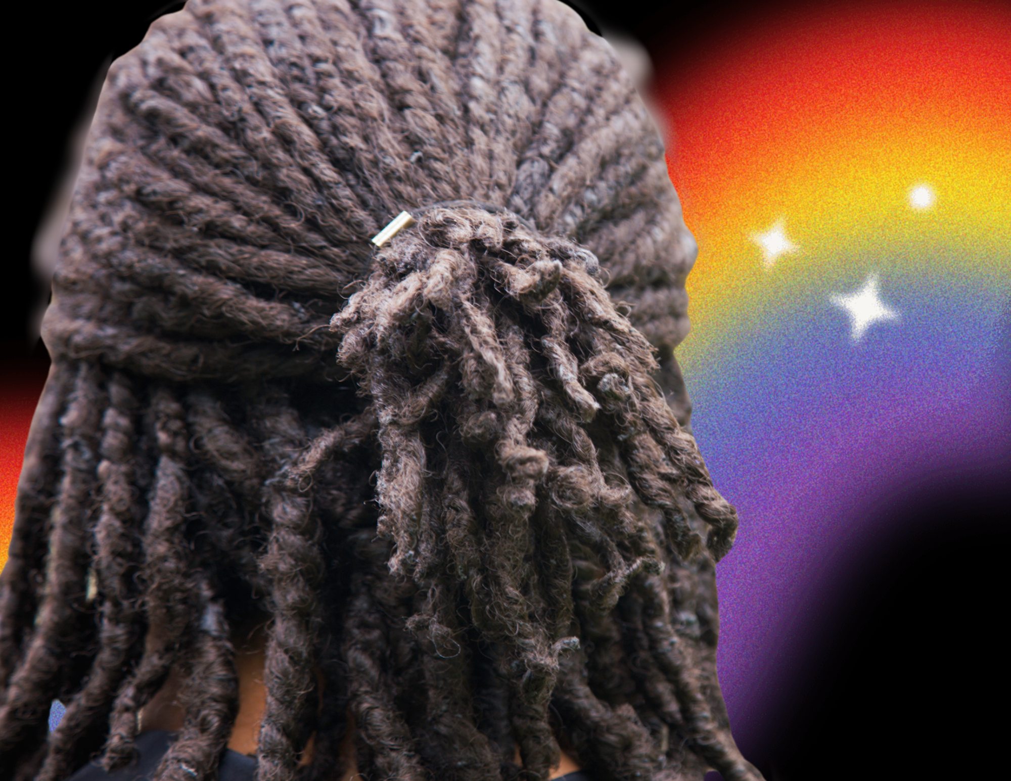 A person with loced hair against a Black background with rainbow spraypaint